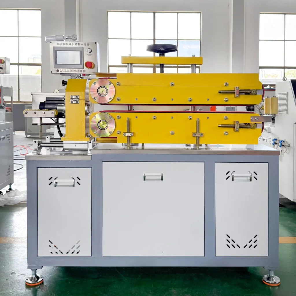 Yellow and white automatic haul-off and cutting machine with visible rollers and a control panel in a factory setting