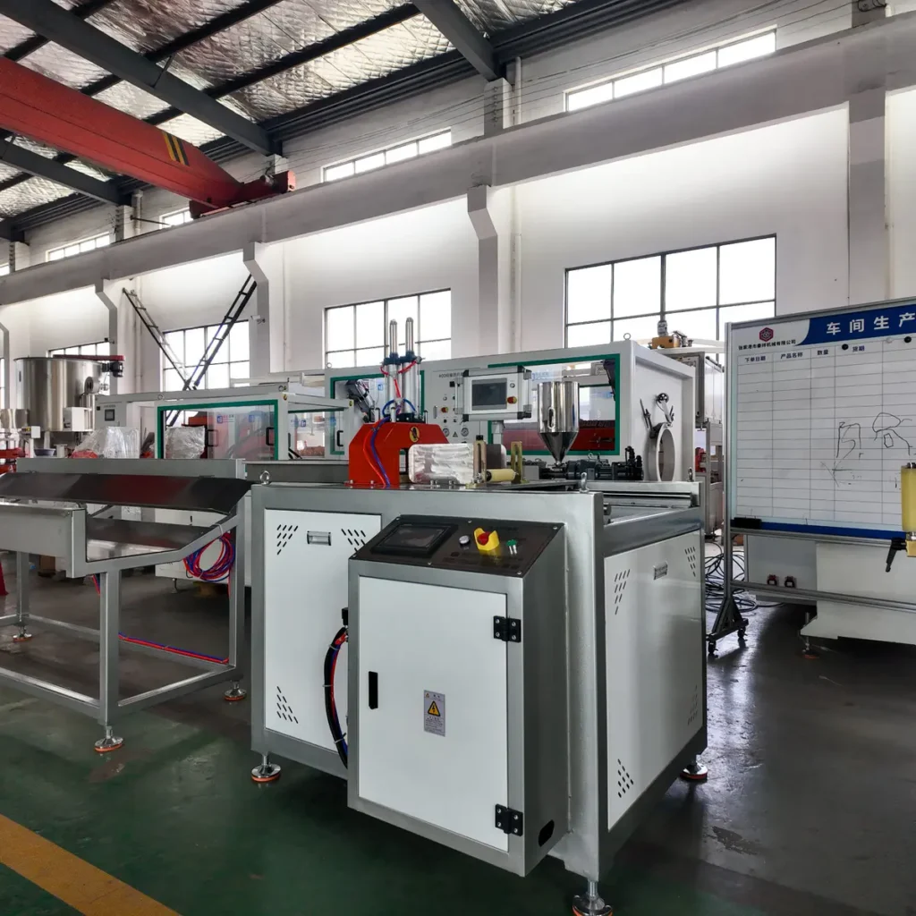 Plastic extrusion machinery with control cabinet and downstream units installed in a factory workshop