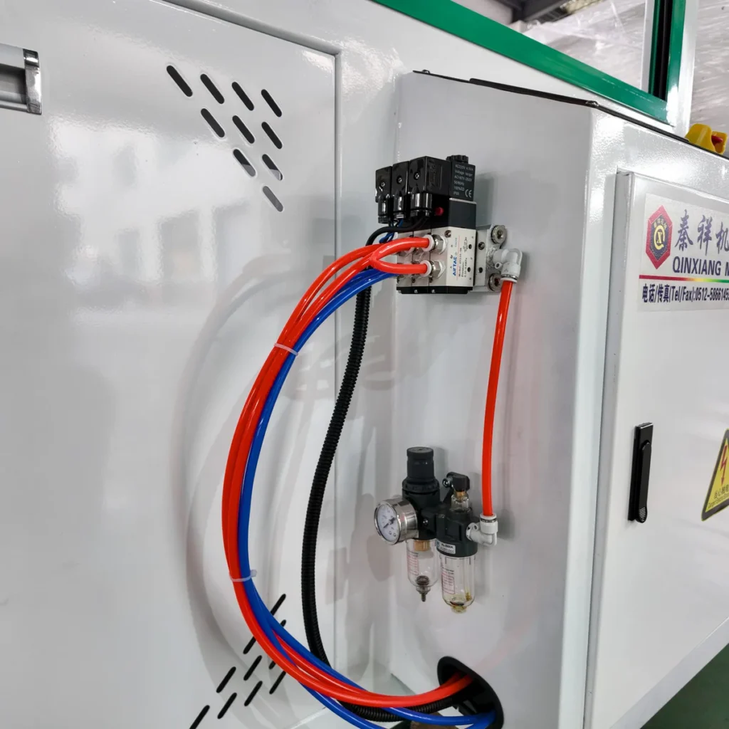 Closeup of pneumatic regulator and solenoid valve mounted on a machine cabinet with colored tubing