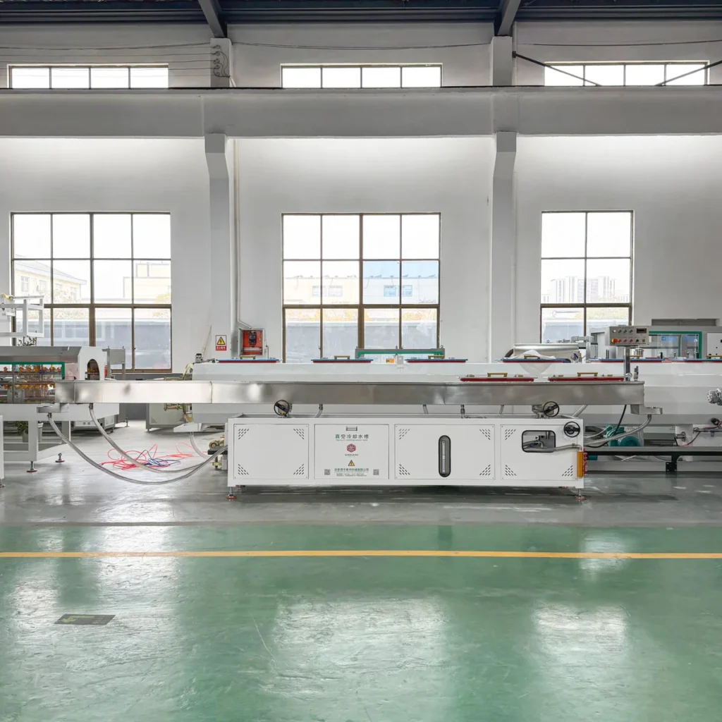 A long vacuum calibration tank with connected downstream equipment is installed on a green factory floor in front of large
