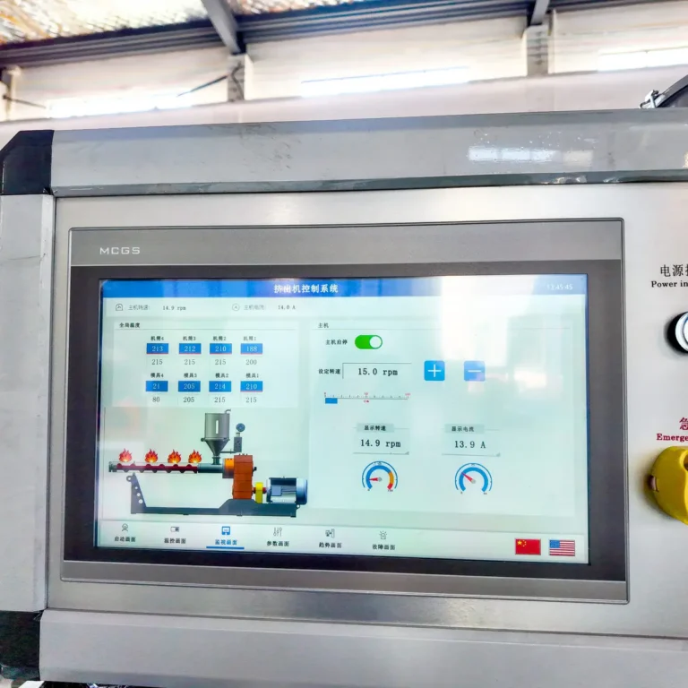 Touchscreen control panel displaying extruder settings and a diagram, with a factory ceiling and windows in the background
