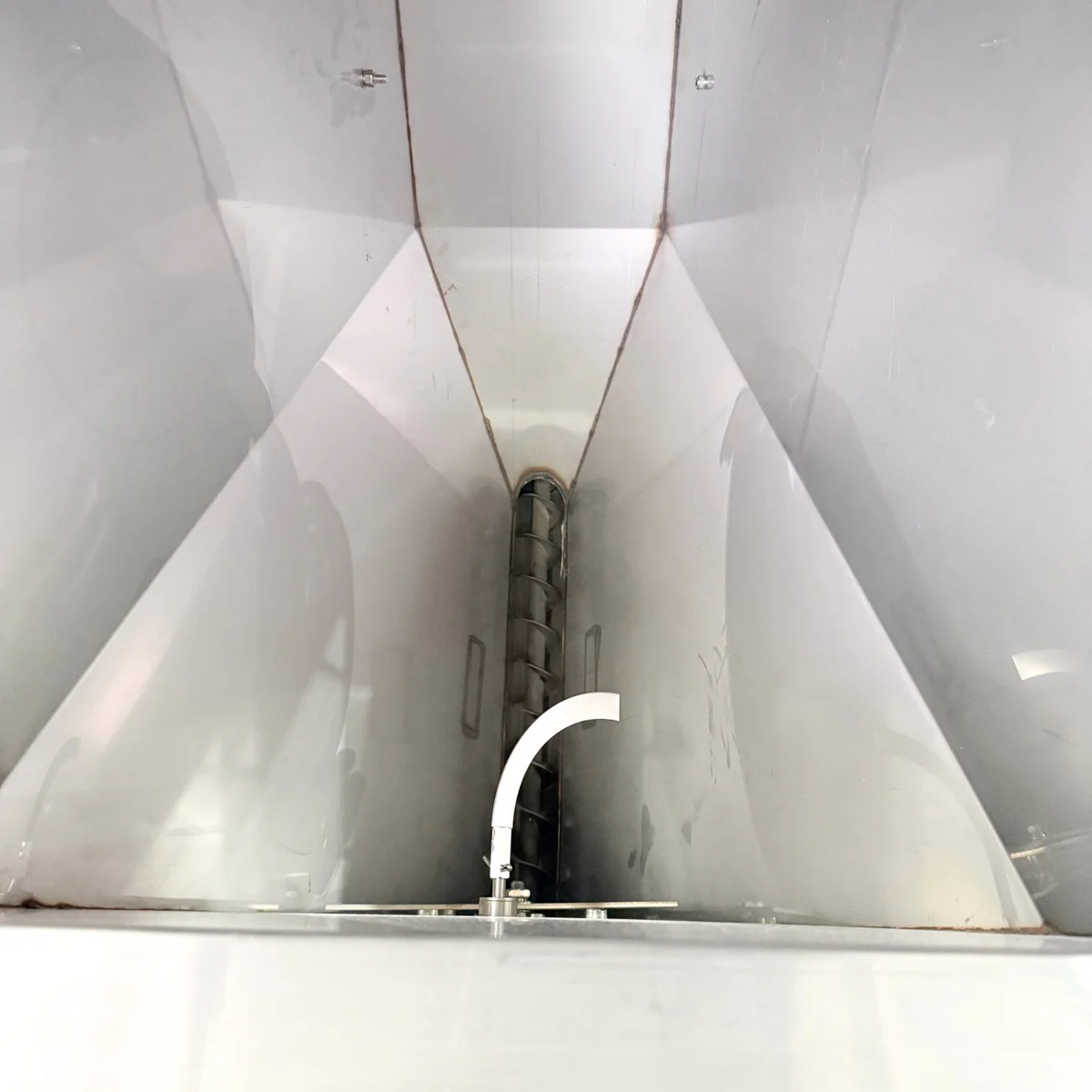 Material arched above the hopper outlet while the hopper still holds material