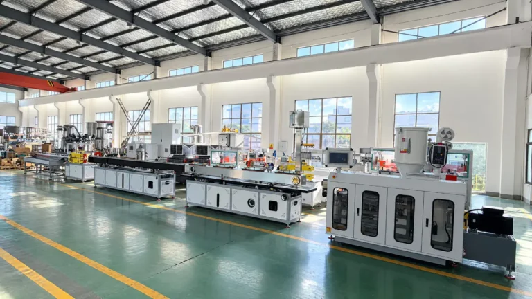 A full extrusion line with multiple downstream units and control cabinets set up in a bright factory workshop
