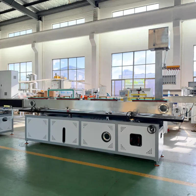 A long vacuum calibration tank with a metallic finish is installed on a factory floor with bright windows in the background