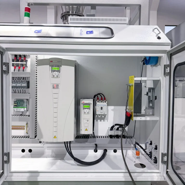 Open control cabinet showing ABB inverters, wiring, and electrical components installed in a factory environment