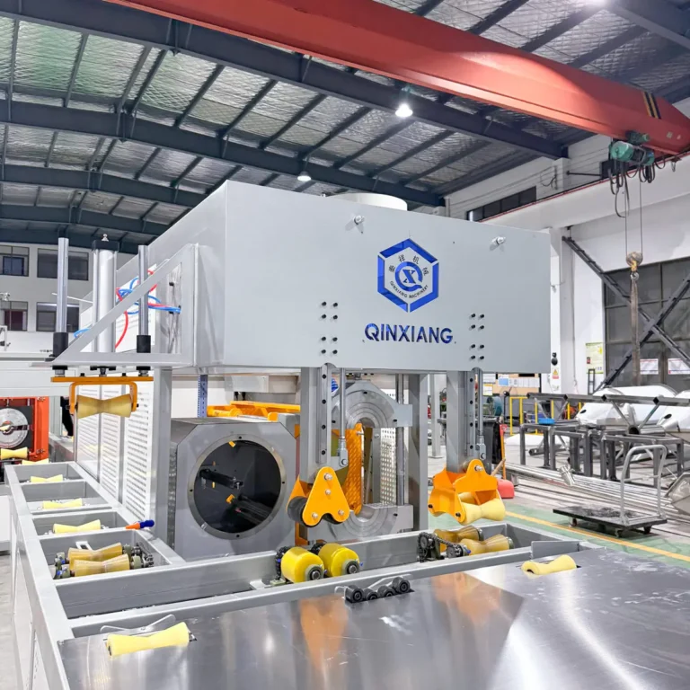 A large section of extrusion machinery with rollers and a cooling or calibration unit installed in a spacious industrial