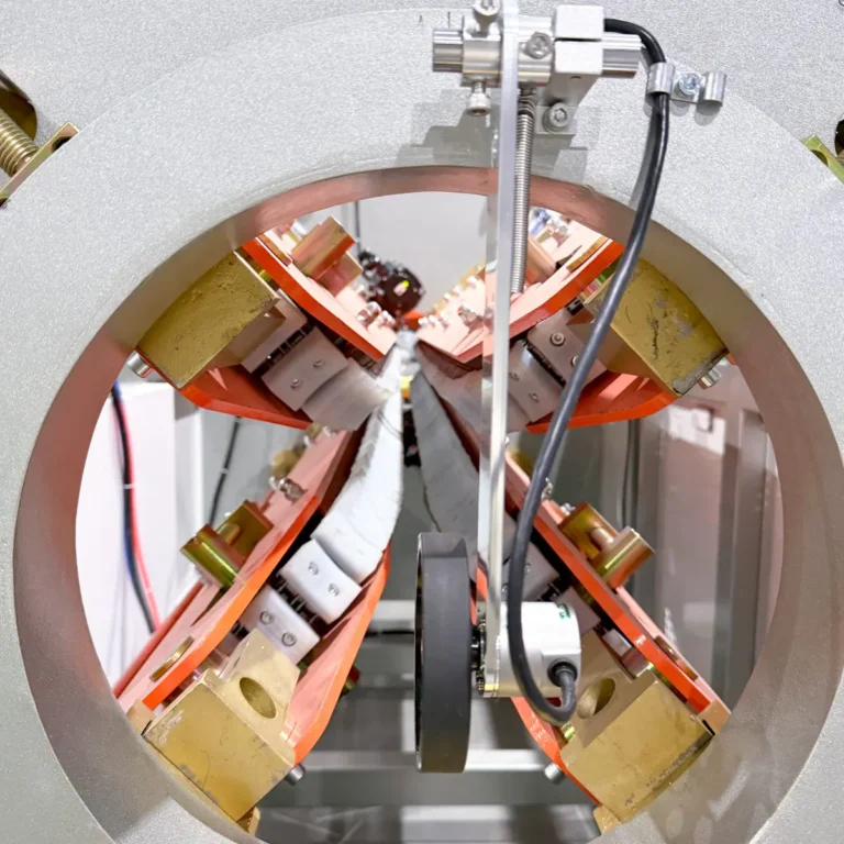 Closeup view of the haul-off unit with multiple rollers and sensors inside a circular frame on a PVC pipe extrusion line