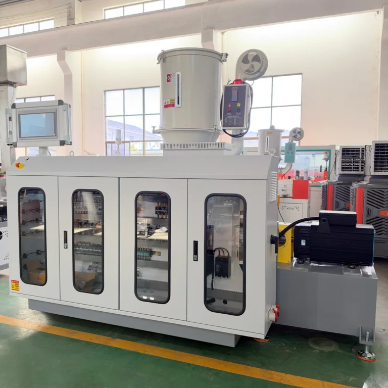 Large white electrical control cabinet with a hopper and motor, installed in a factory workshop with windows