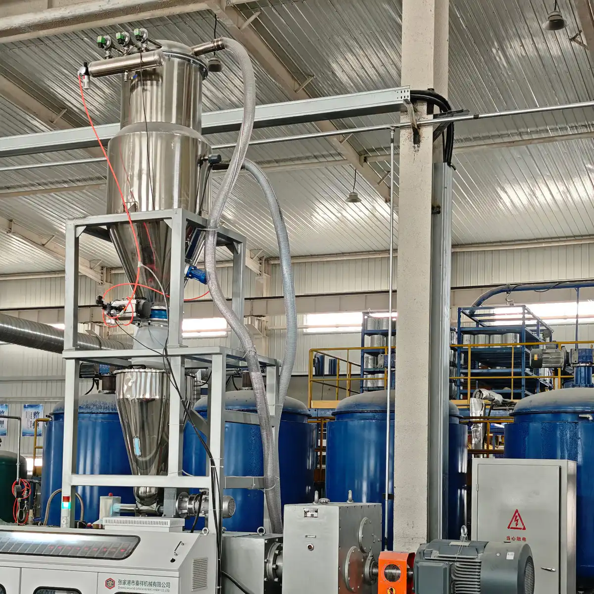 Vacuum loader conveying resin from storage to the extruder hopper on a pipe line